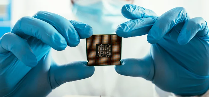  Microchip held with protective gloves in a laboratory for environmental simulation and electronics testing