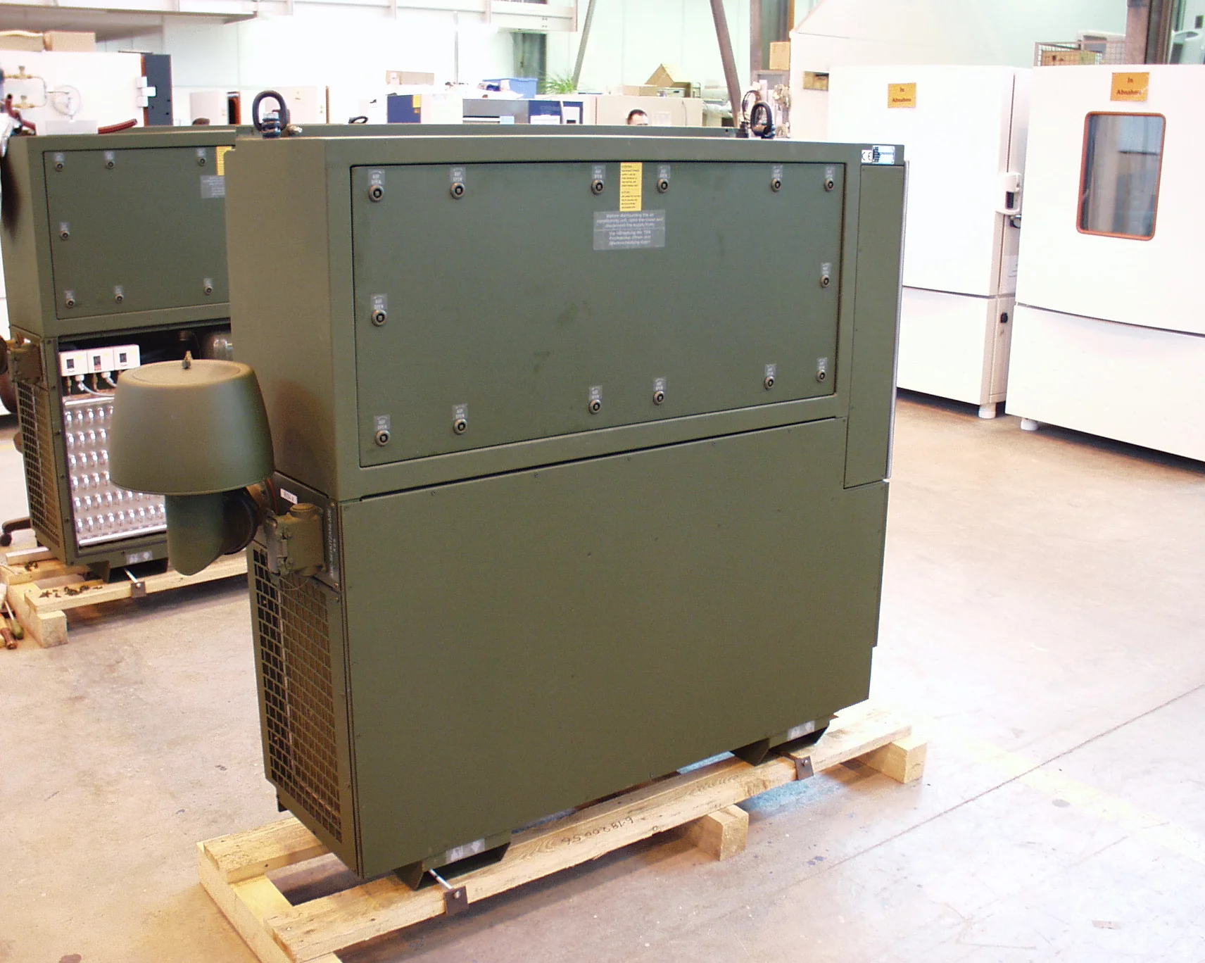  Tactical TKA series air conditioning unit from Weiss Defence on a pallet in an industrial hall.