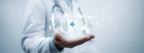 Symbolische Darstellung von Gesundheit und Schutz im medizinischen Umfeld mit digitalem Icon über einer ausgestreckten Hand