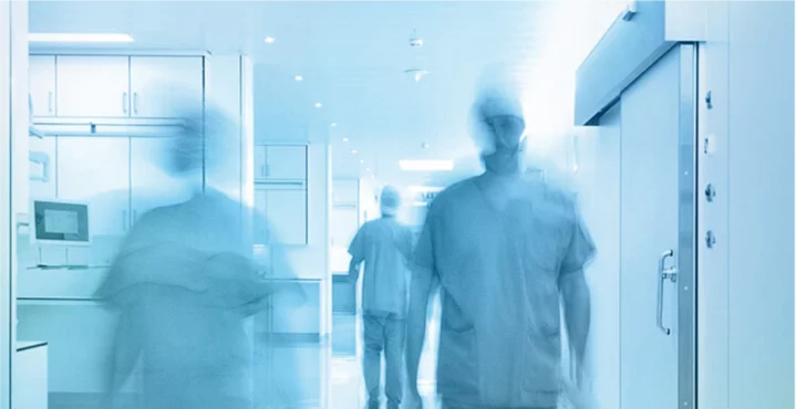 Medical staff moving through a hygienically climate‑controlled hospital corridor with controlled air quality