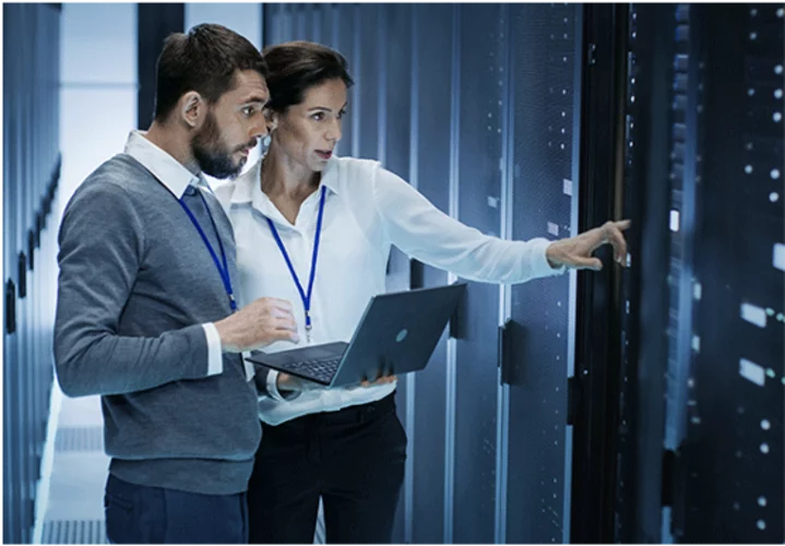 Technical staff monitor climate control in a data center between server racks
