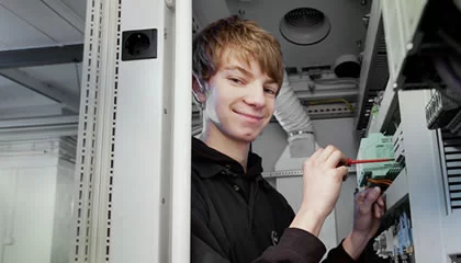Mechatronics apprentice working on electrical control cabinet technology at Weiss Technik